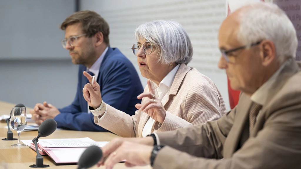 Bundesrätin Elisabeth Baume-Schneider, Mitte, spricht neben Thomas Christen, stellvertretender Direktor des Bundesamtes für Gesundheit (BAG), links, und Pierre Alain Schnegg, Berner Regierungsrat und Praesident der Organisation ambulante Arzttarife (OAAT AG), rechts, an einer Medienkonferenz im Medienzentrum des Bundesrats in Bern.