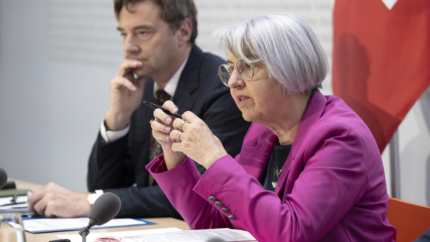 Bundesrätin Elisabeth Baume-Schneider sitzt an einem Pult im Medienzentrum des Bundesrats und ist am Sprechen. Hinter ihr sitzt Andreas Rieder, Leiter Eidgenössisches Büro für die Gleichstellung von Menschen mit Behinderungen.