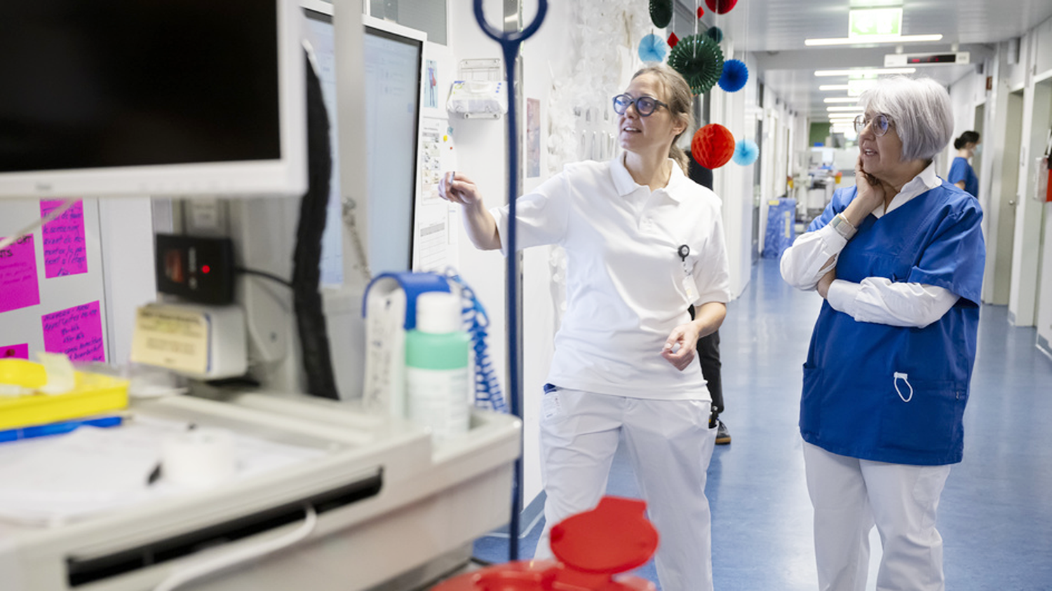 Bundesrätin Elisabeth Baume-Schneider besucht das Spitalzentrum Biel. Sie steht in einem Spital-Gang und lässt sich von einer Mitarbeiterin in weissen Kleidern etwas erklären. 